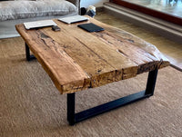Mesa de centro en durmientes de tren recuperados con base de fierro negro, diseño robusto y estilo industrial contemporáneo.