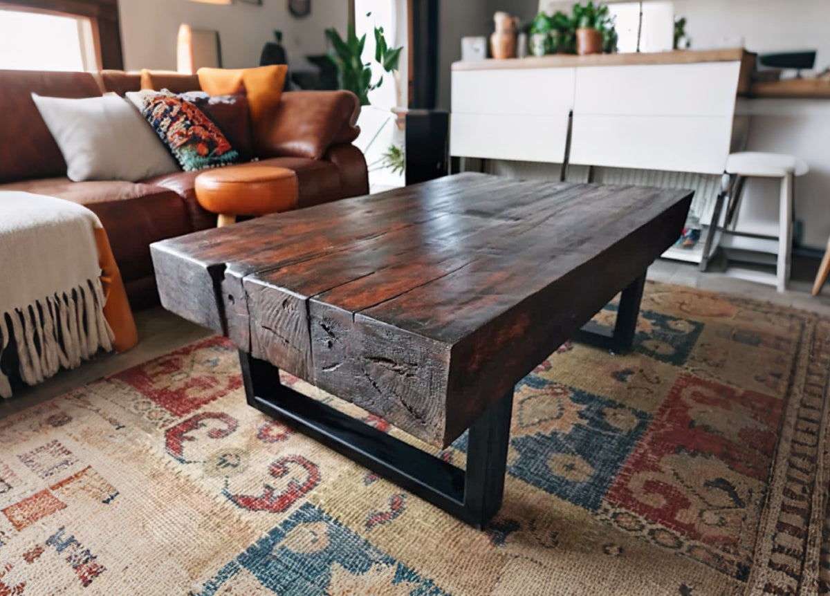 Mesa de centro en durmientes de tren recuperados con base de fierro negro, diseño robusto y estilo industrial contemporáneo.