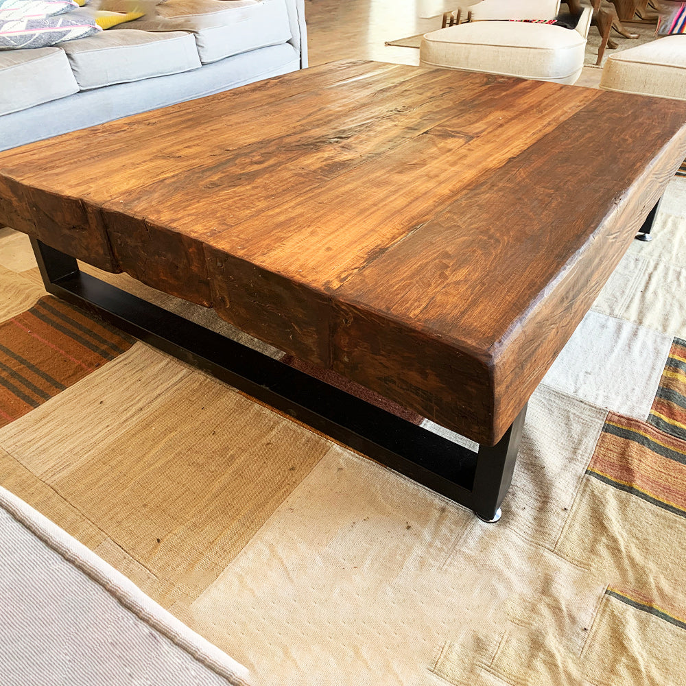 Vista lateral de mesa de centro en madera recuperada con estructura metálica, ideal para espacios modernos.