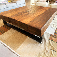 Vista lateral de mesa de centro en madera recuperada con estructura metálica, ideal para espacios modernos.